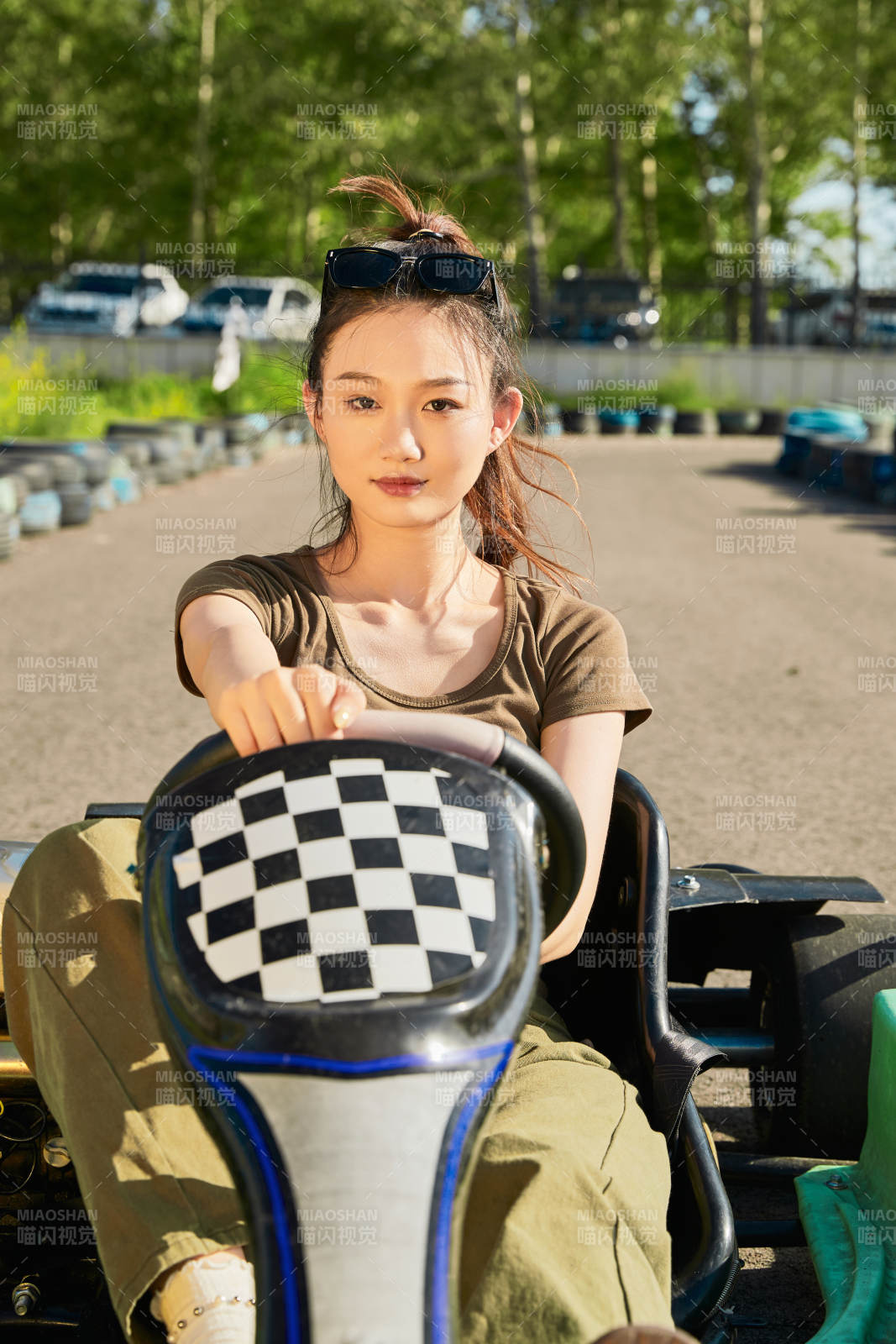 在游乐场卡丁赛道上驾驶卡丁车的美女图片