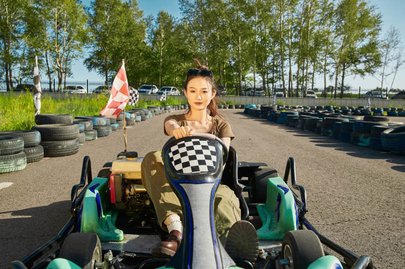 在游乐场卡丁赛道上驾驶卡丁车的美女图片