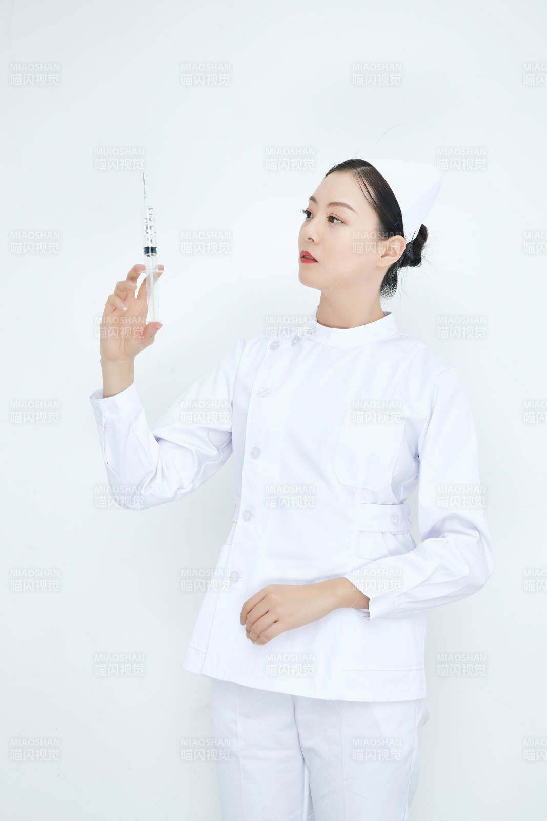 穿护士服戴口罩手执针筒的年轻女护士图片