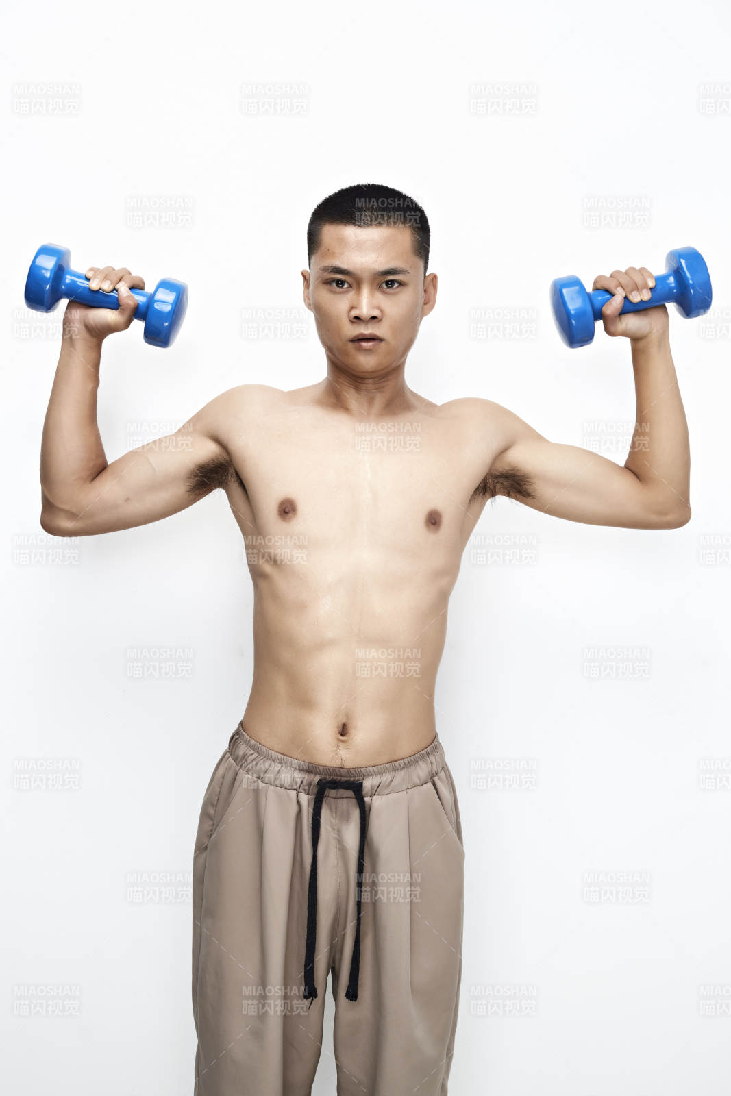 使用哑铃进行健身锻炼的亚洲男性图片