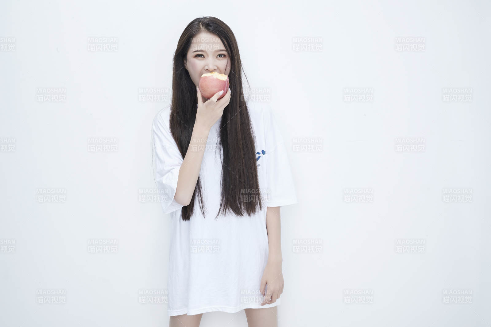 吃苹果的穿白色长T血衫的长发可爱少女人像图片