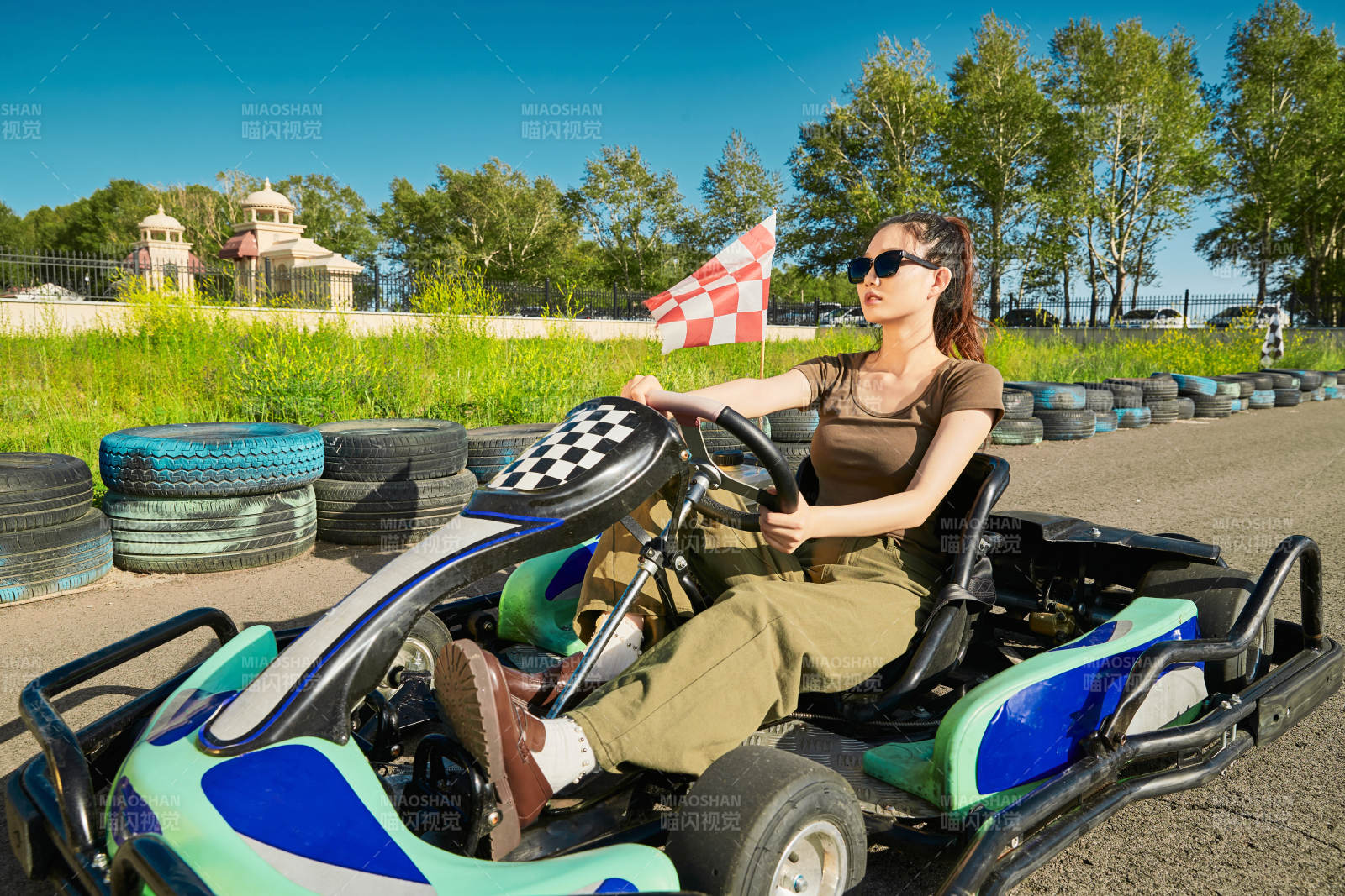 在游乐场卡丁赛道上驾驶卡丁车的美女图片