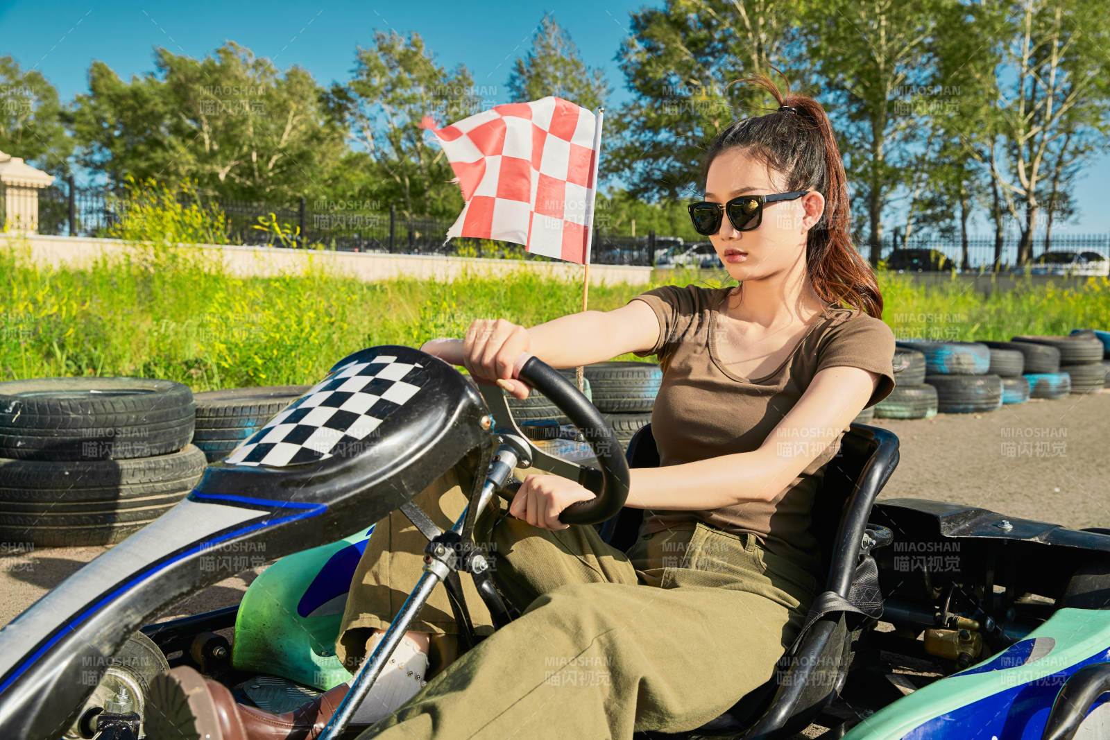 在游乐场卡丁赛道上驾驶卡丁车的美女图片