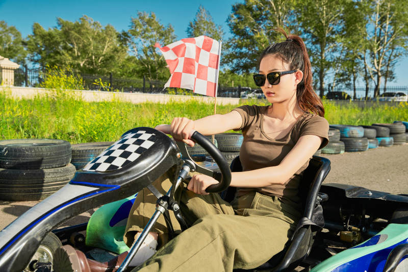 在游乐场卡丁赛道上驾驶卡丁车的美女图片