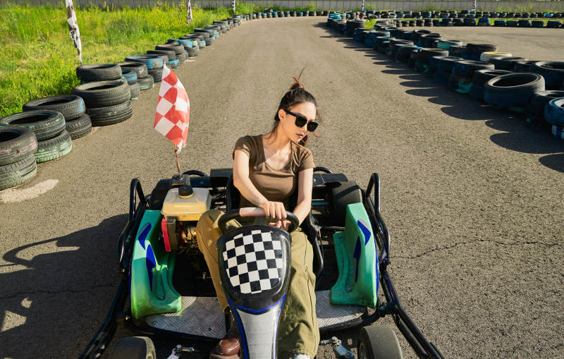 在游乐场卡丁赛道上驾驶卡丁车的美女图片