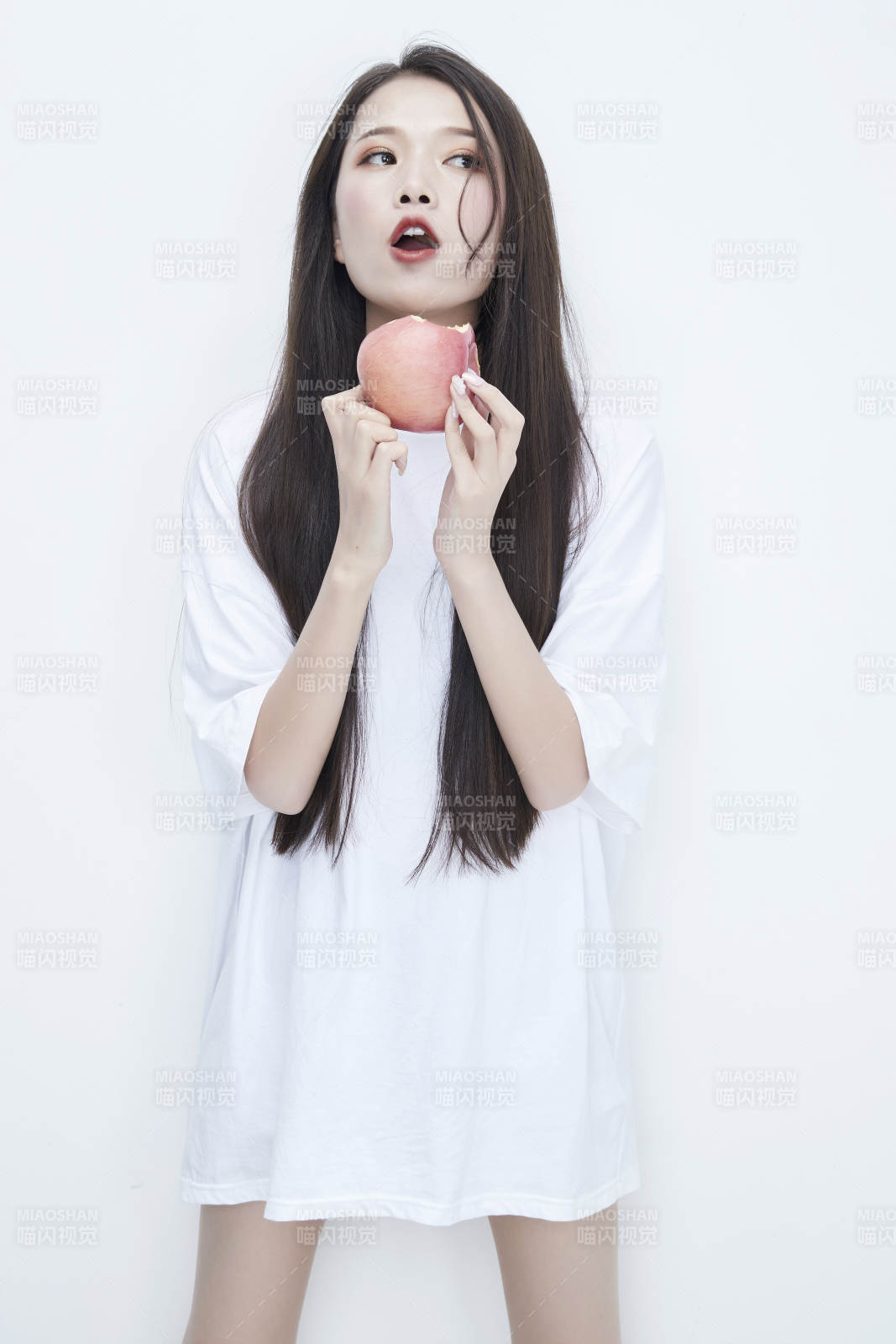 吃苹果的穿白色长T血衫的长发可爱少女人像图片