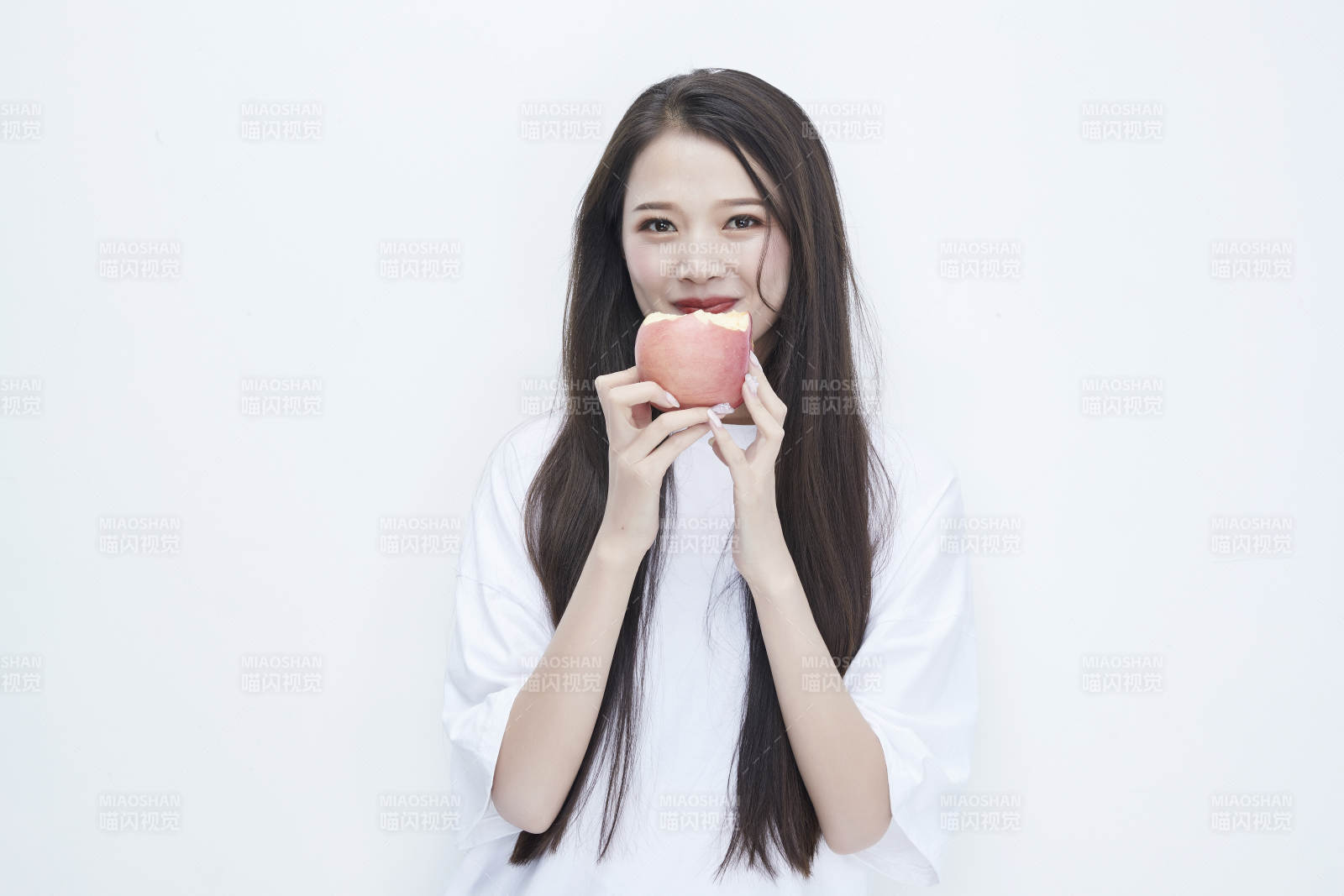 吃苹果的穿白色长T血衫的长发可爱少女人像图片
