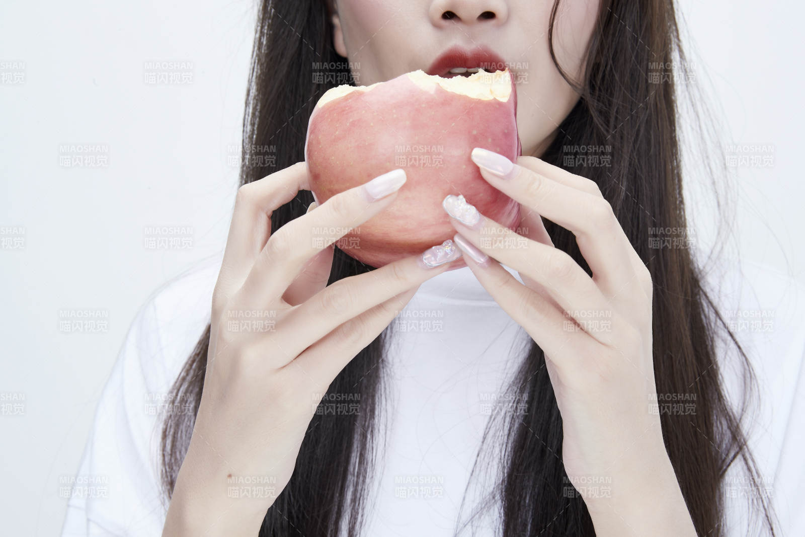 吃苹果的穿白色长T血衫的长发可爱少女人像图片