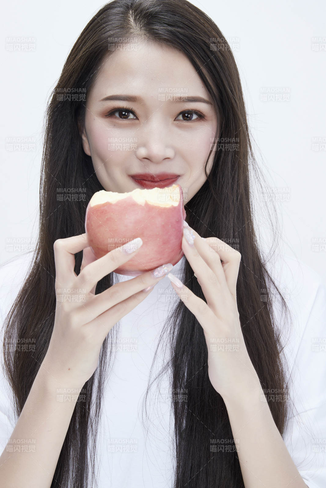吃苹果的穿白色长T血衫的长发可爱少女人像图片