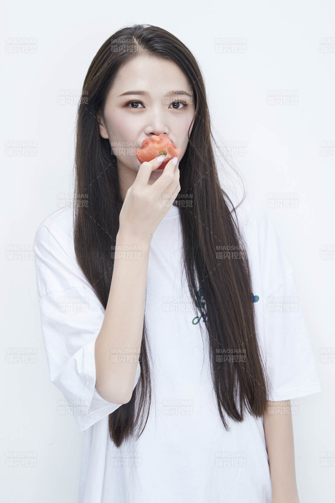 吃番茄的身穿白色长T血衬衫的长发少女人像图片