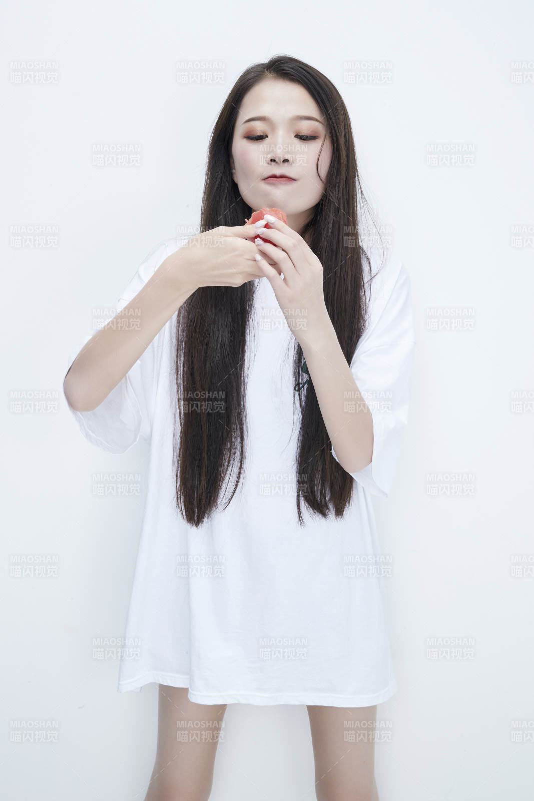 吃番茄的身穿白色长T血衬衫的长发少女人像图片