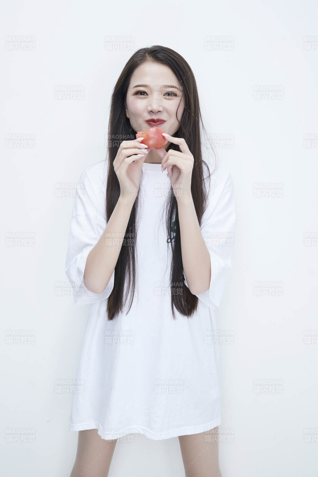 吃番茄的身穿白色长T血衬衫的长发少女人像图片