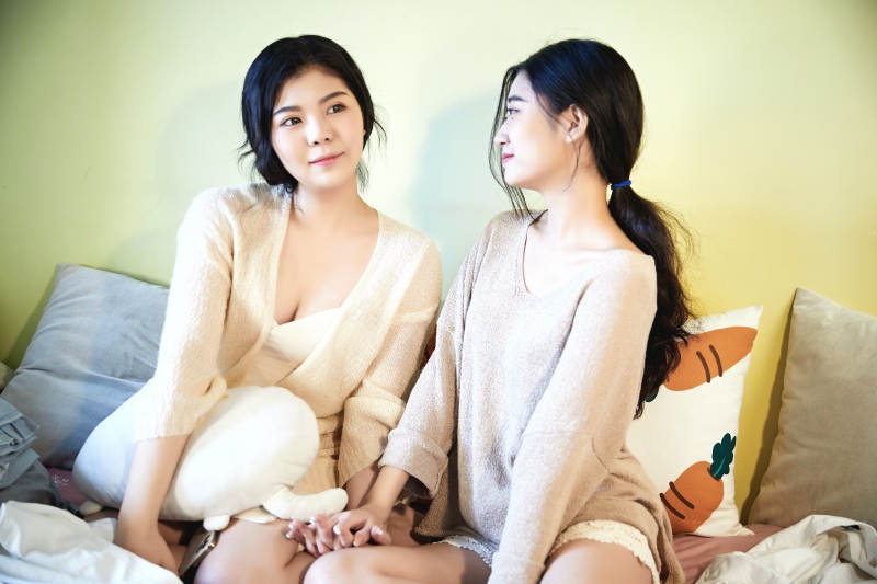 坐在床上的俩位美女图片