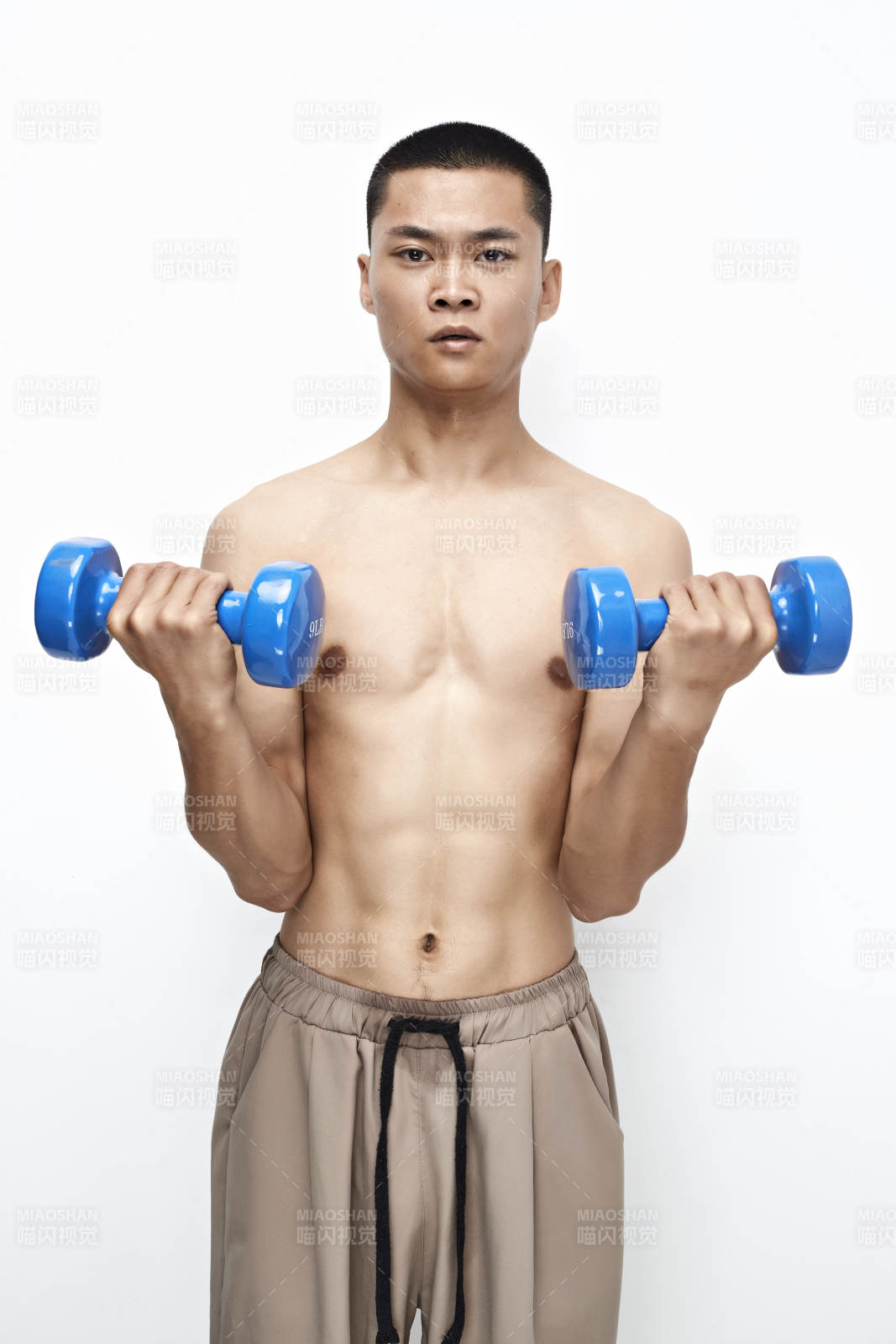 使用哑铃进行健身锻炼的亚洲男性图片