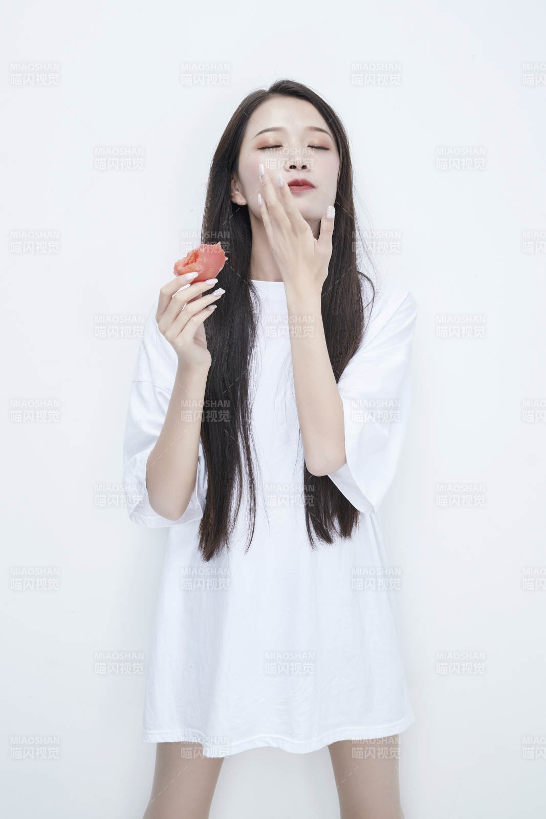 吃番茄的身穿白色长T血衬衫的长发少女人像图片