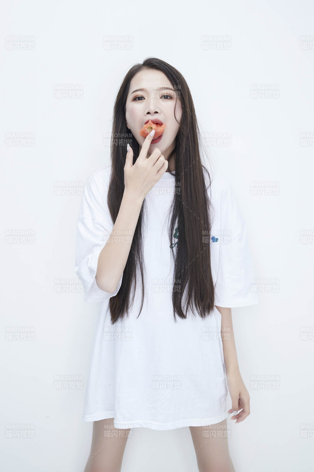 吃番茄的身穿白色长T血衬衫的长发少女人像图片