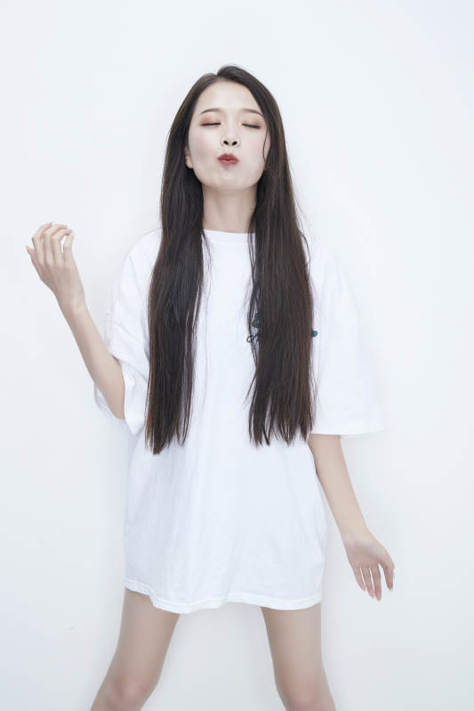 吃番茄的身穿白色长T血衬衫的长发少女人像图片