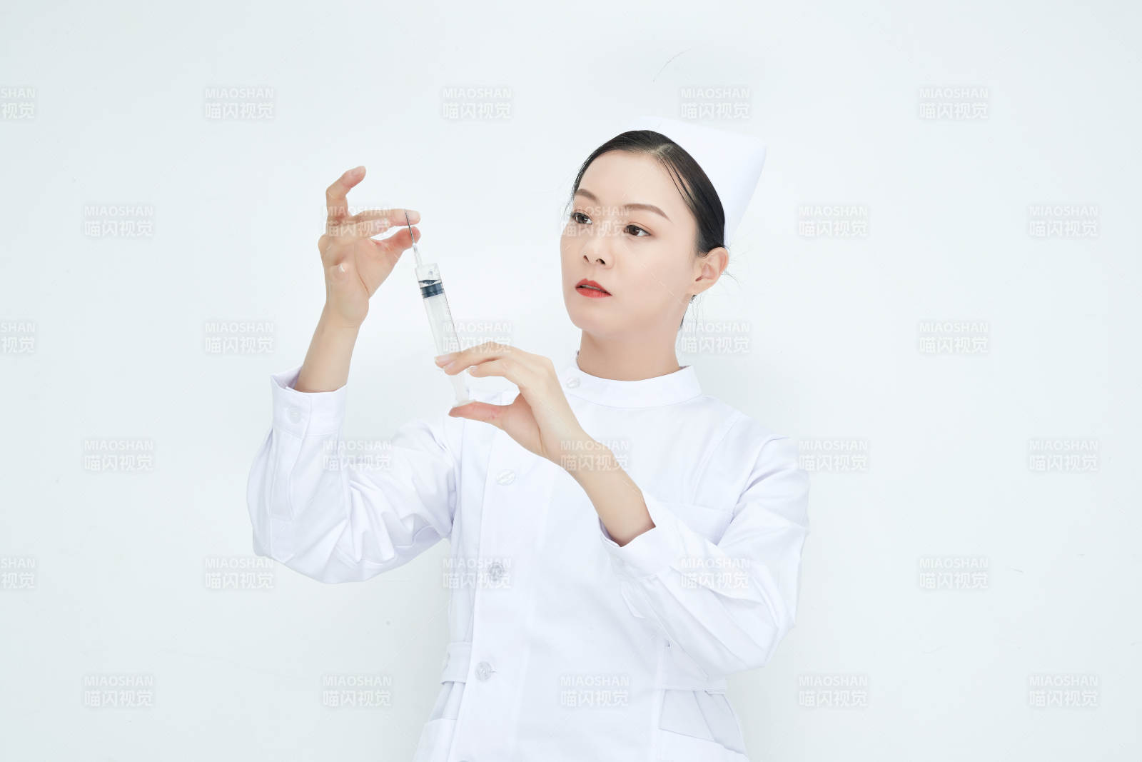 穿护士服戴口罩手执针筒的年轻女护士图片