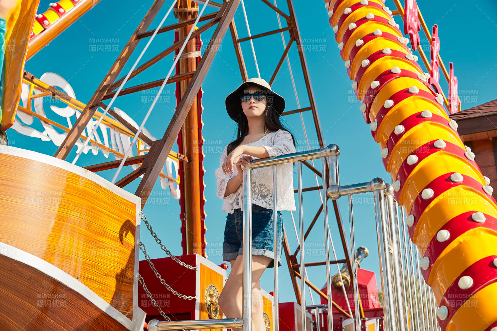 站在游乐场海盗船旁边的美女图片