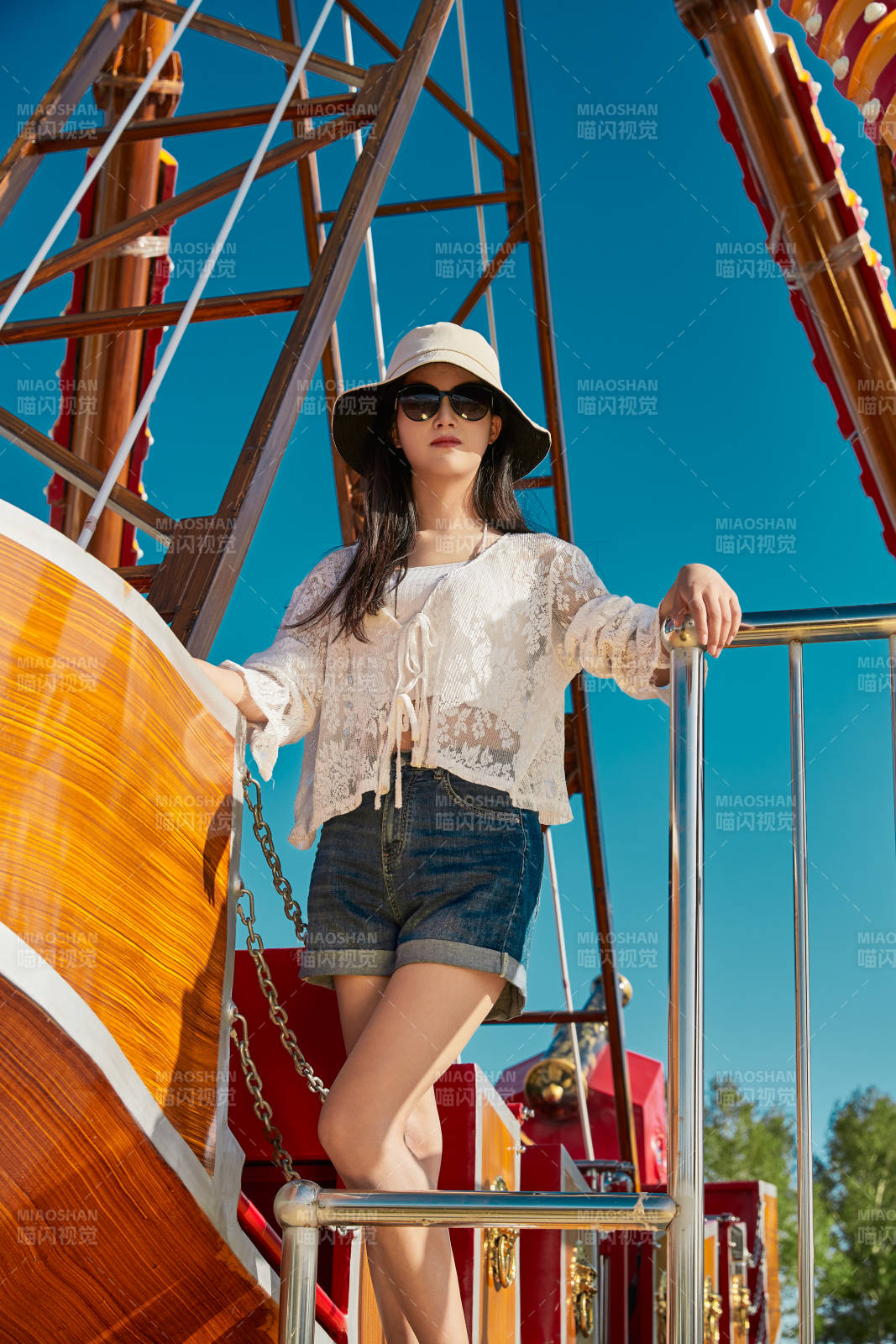 站在游乐场海盗船旁边的美女图片