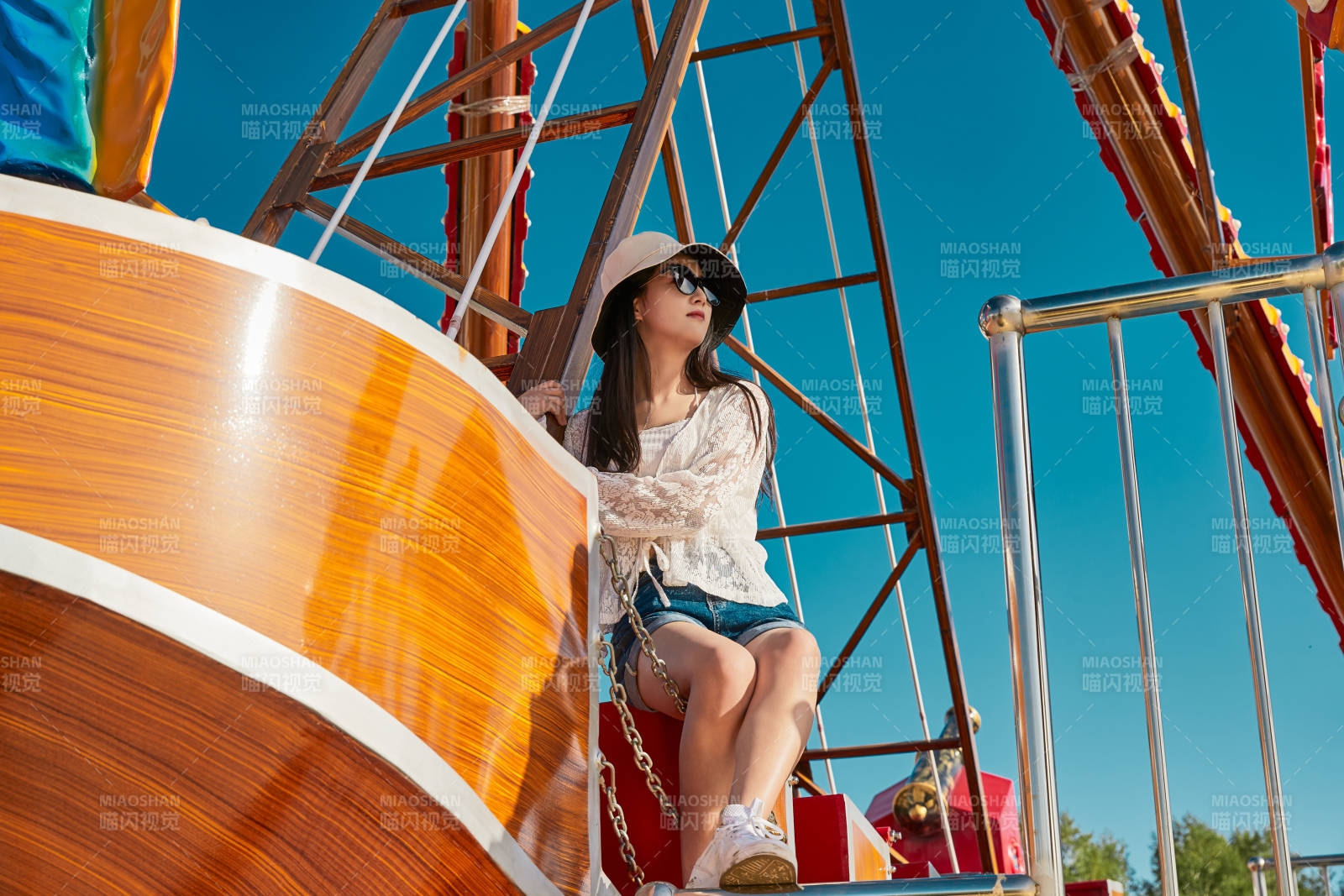 站在游乐场海盗船旁边的美女图片