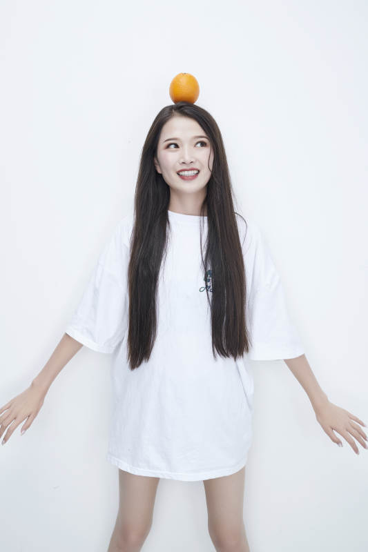玩耍橙子穿白色长T血的亚洲可爱少女人像图片