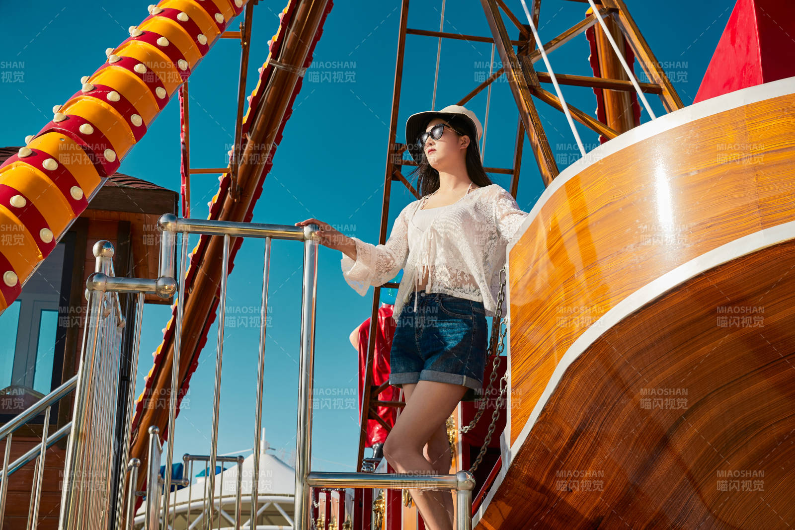 站在游乐场海盗船旁边的美女图片