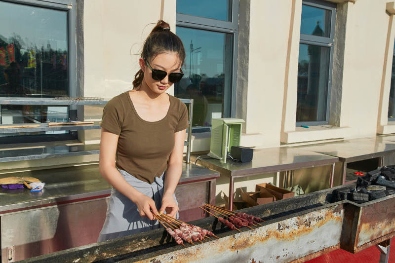 卖力烤羊肉串的美女图片
