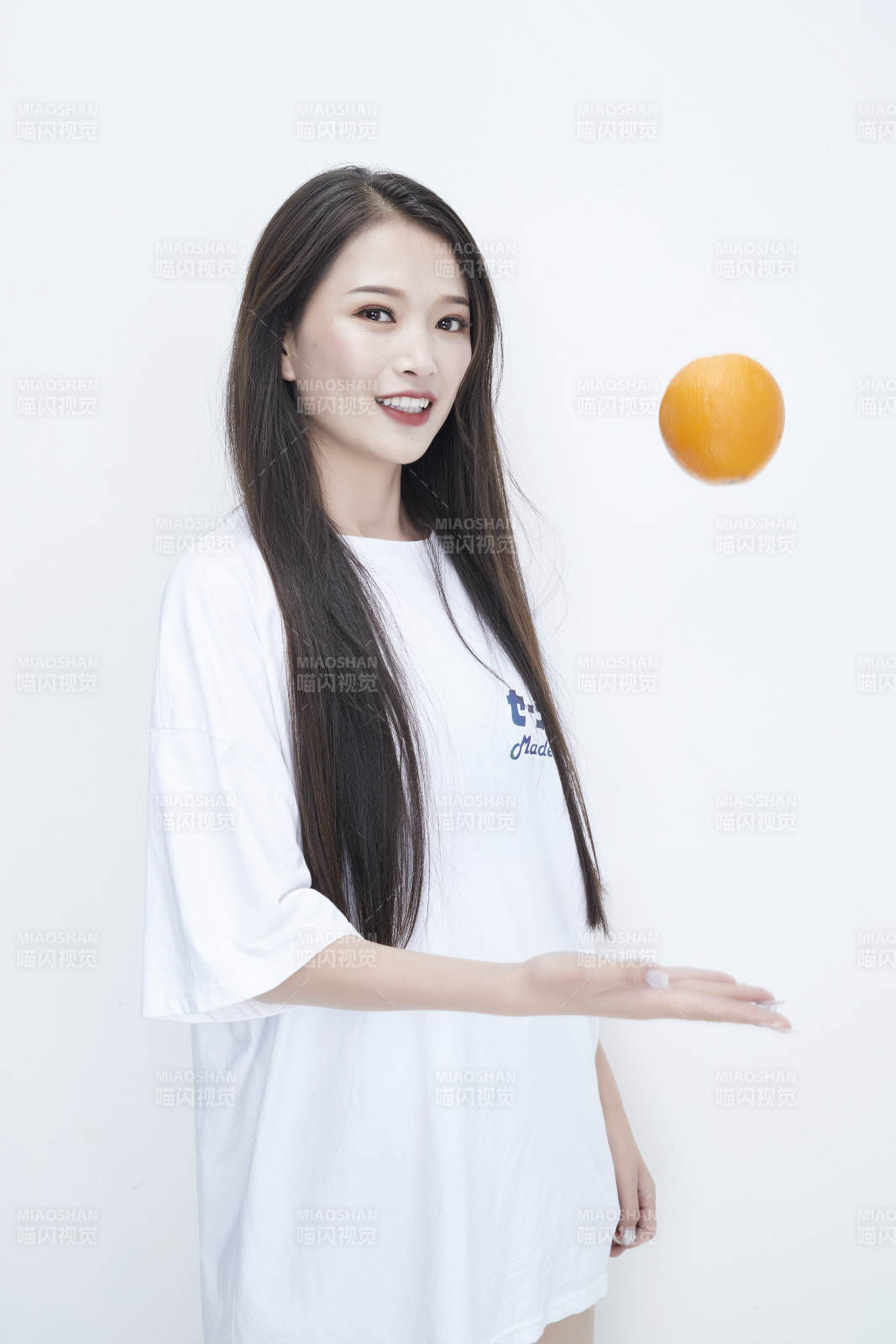 玩耍橙子穿白色长T血的亚洲可爱少女人像图片