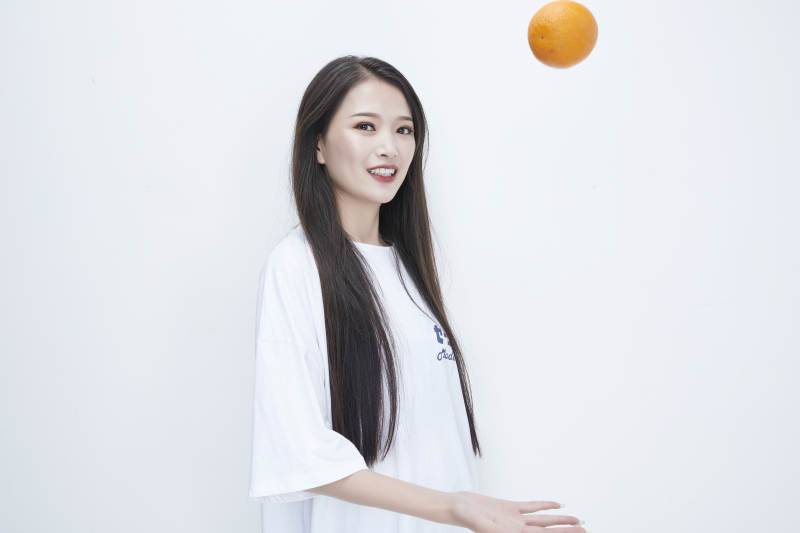 玩耍橙子穿白色长T血的亚洲可爱少女人像图片