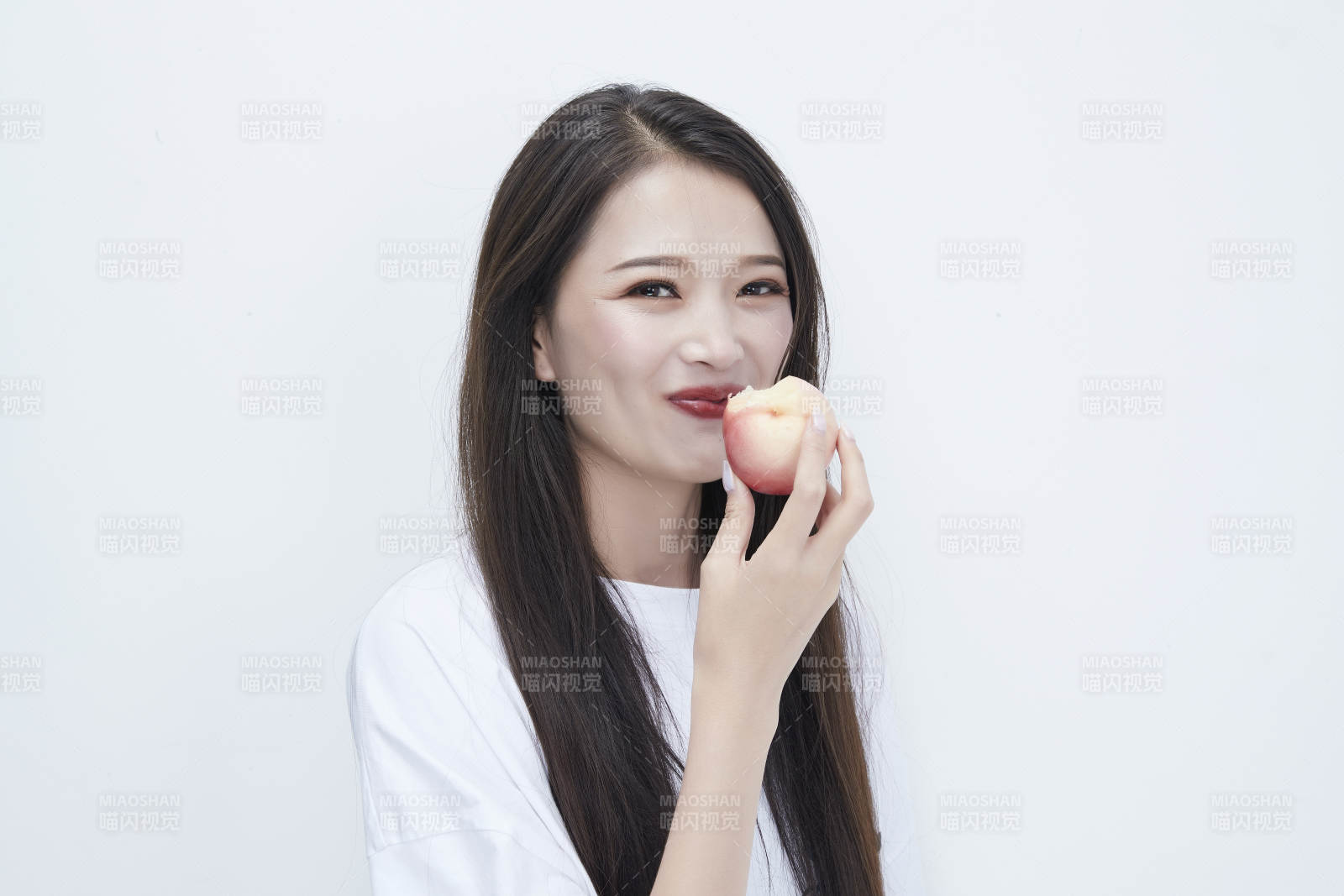 吃桃子的穿白色长T血衫的长发可爱少女人像图片