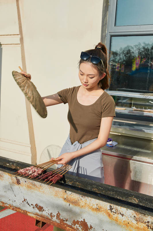 卖力烤羊肉串的美女图片