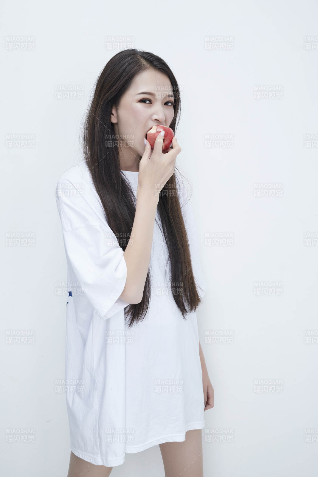 吃桃子的穿白色长T血衫的长发可爱少女人像图片