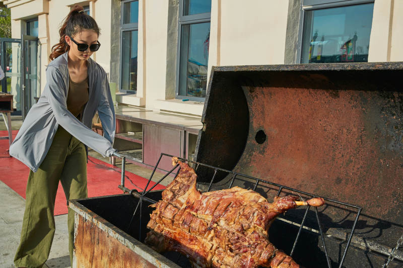 在翻转烤炉内烤全羊的美女图片