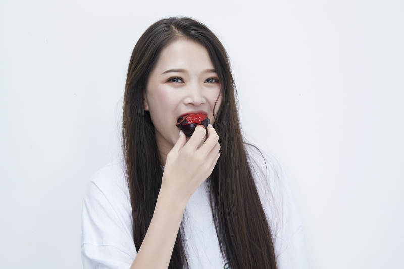 吃黑李子穿白色长T血衫的长发可爱少女人像图片