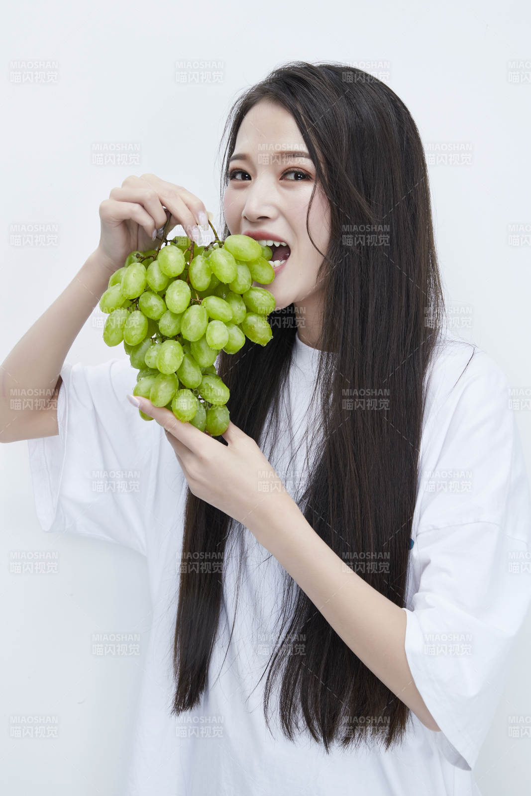 吃葡萄的穿白色长T血衫的长发可爱少女人像图片