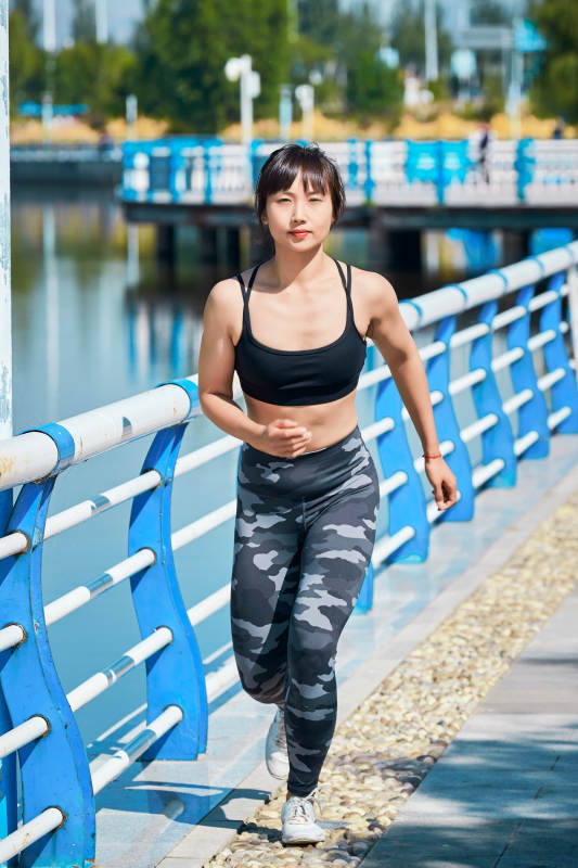 户外河畔公园做拉伸有氧运动的亚洲女性图片