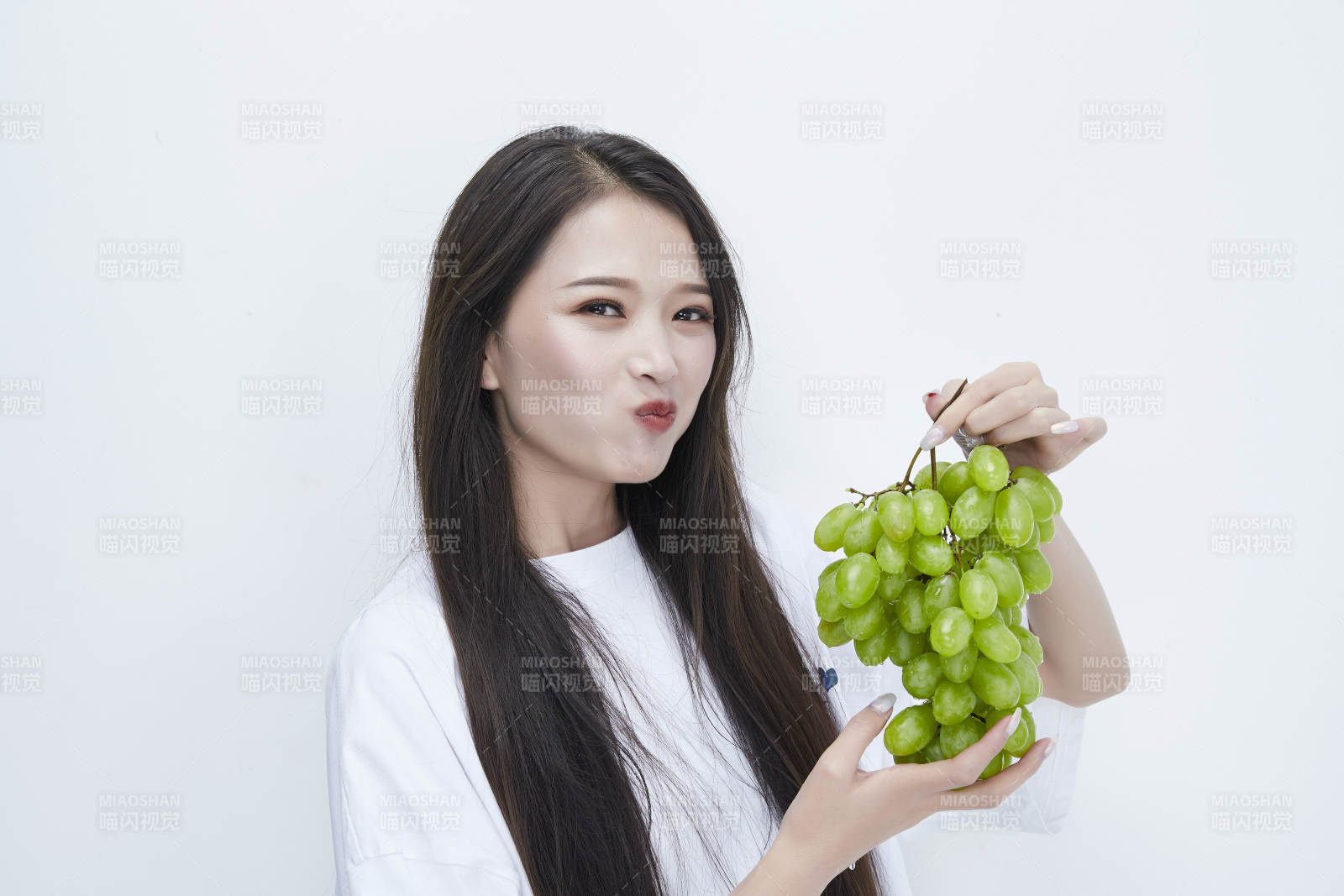 吃葡萄的穿白色长T血衫的长发可爱少女人像图片