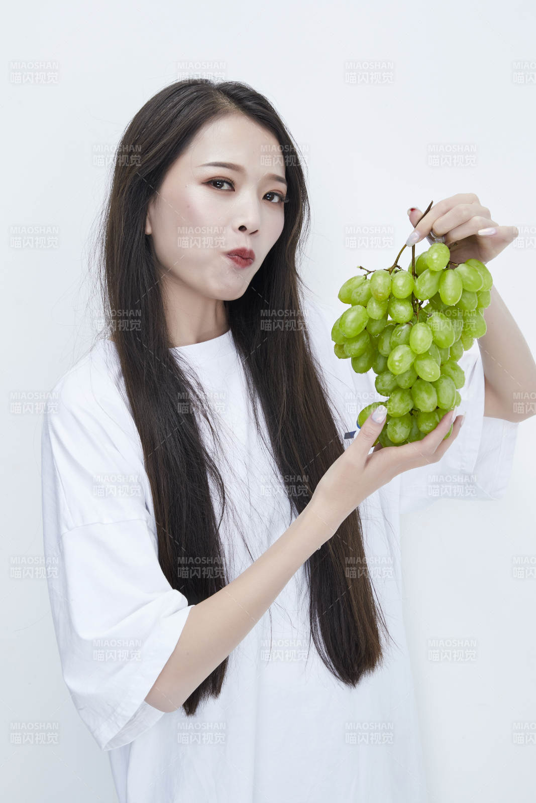 吃葡萄的穿白色长T血衫的长发可爱少女人像图片