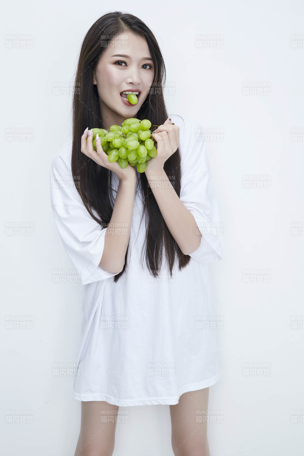 吃葡萄的穿白色长T血衫的长发可爱少女人像图片