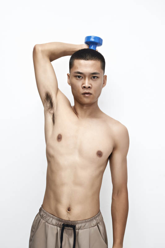 使用哑铃进行健身锻炼的亚洲男性图片
