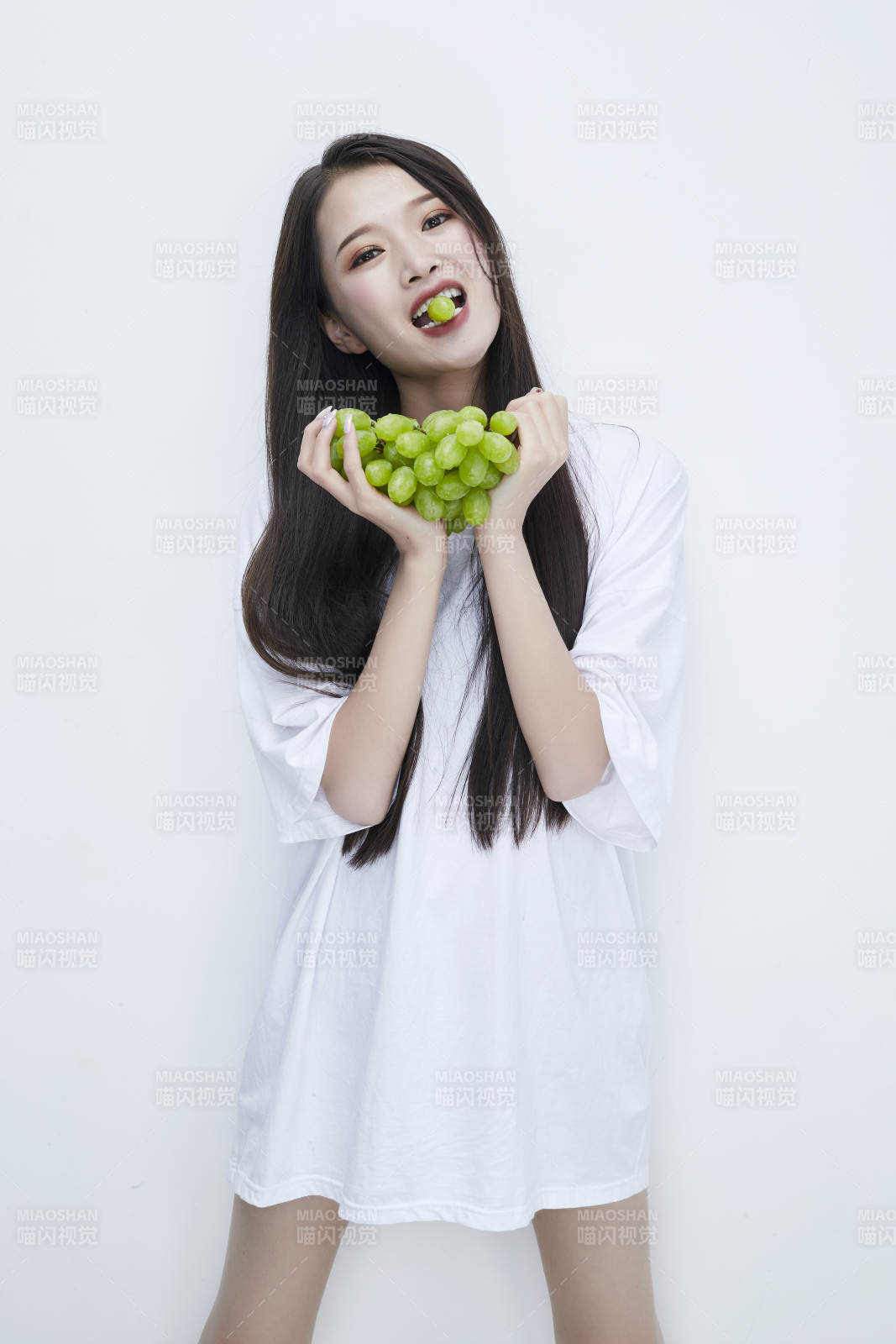 吃葡萄的穿白色长T血衫的长发可爱少女人像图片