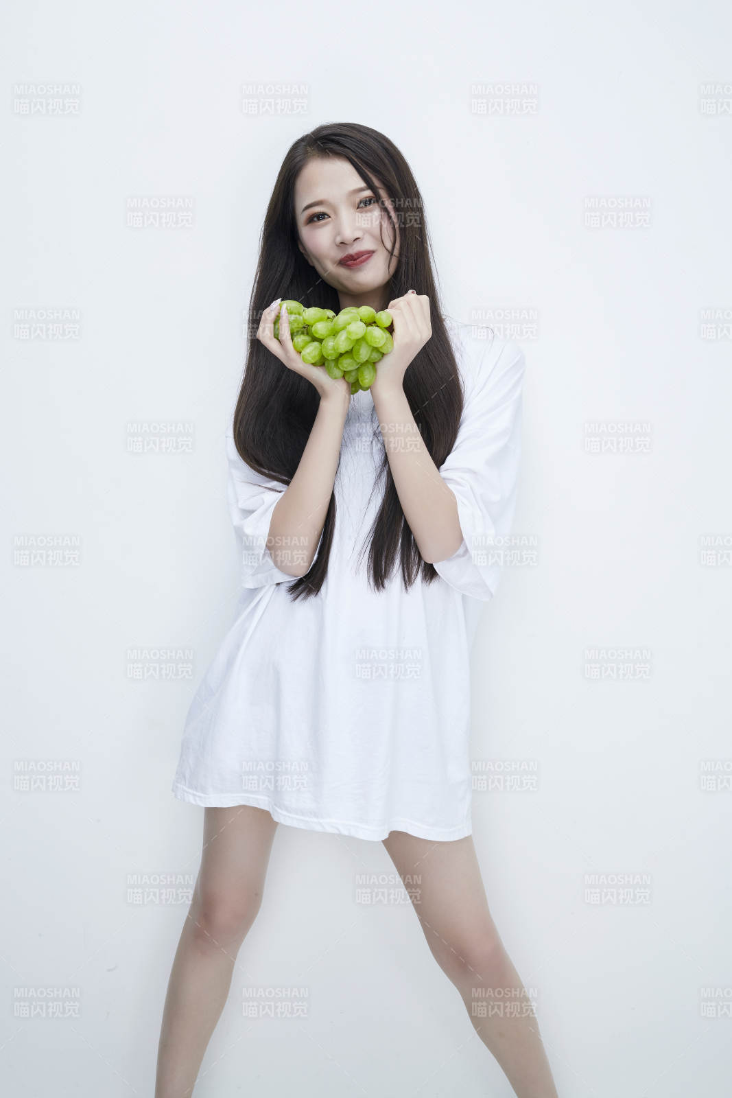 吃葡萄的穿白色长T血衫的长发可爱少女人像图片