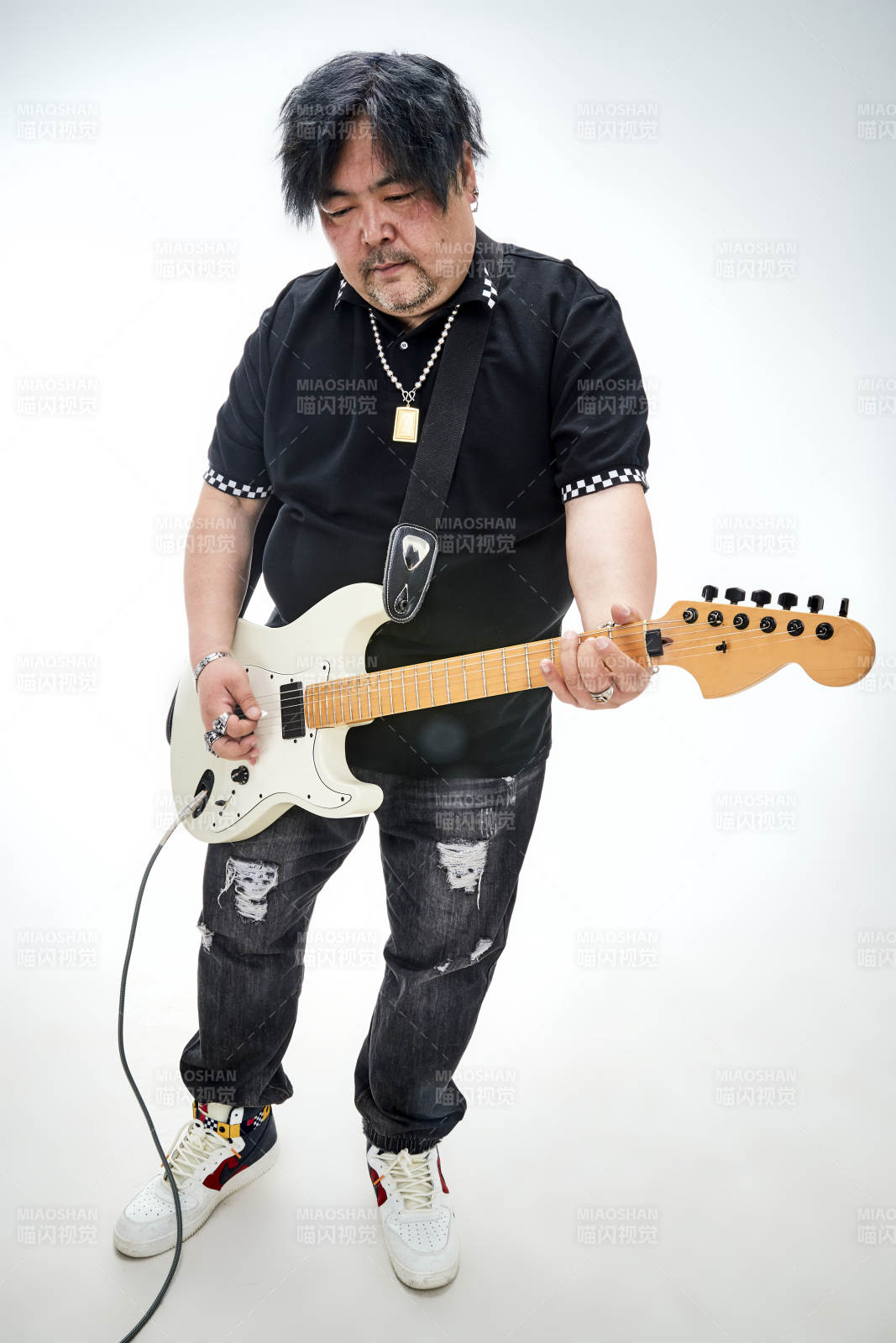 手持电吉他展示演奏的亚洲男性摇滚乐手人像图片