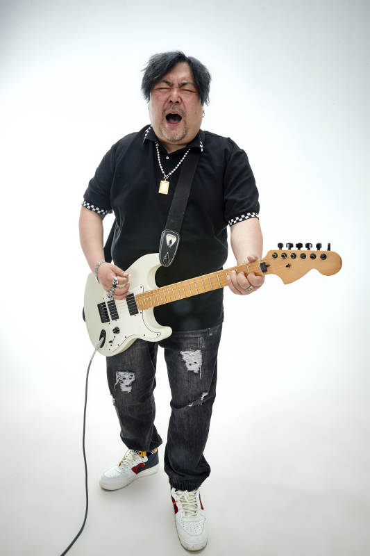 手持电吉他展示演奏的亚洲男性摇滚乐手人像图片