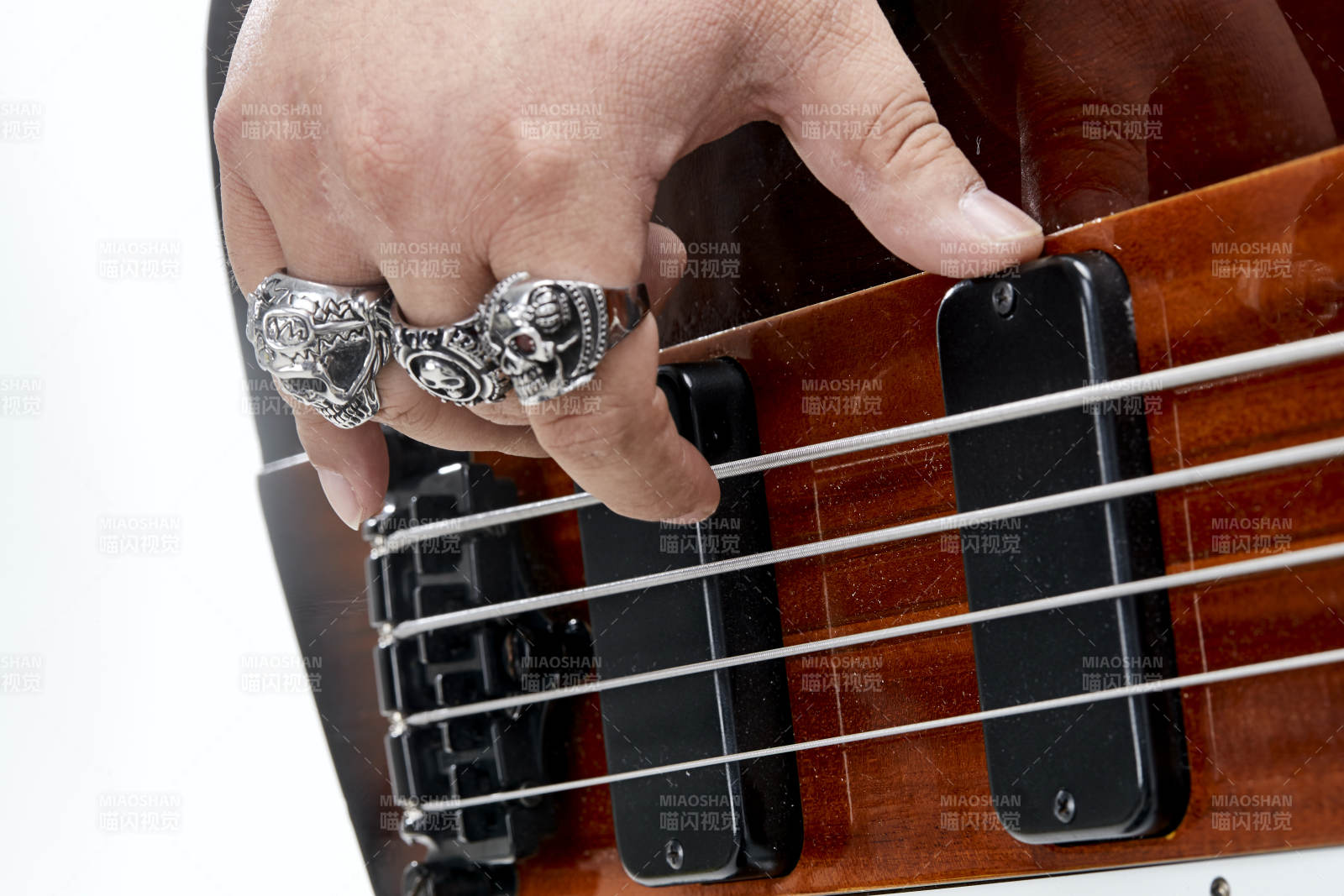 展示贝斯演奏技术技巧的亚洲男性乐手人像局部特写图片