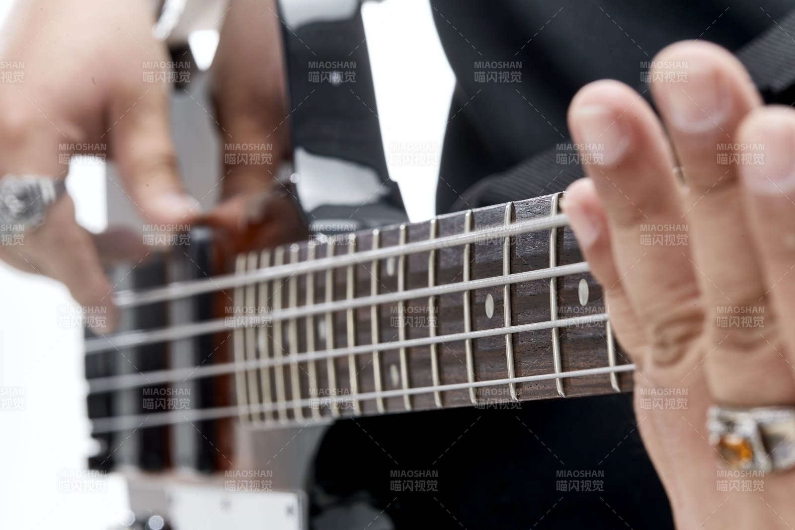 展示贝斯演奏技术技巧的亚洲男性乐手人像局部特写图片