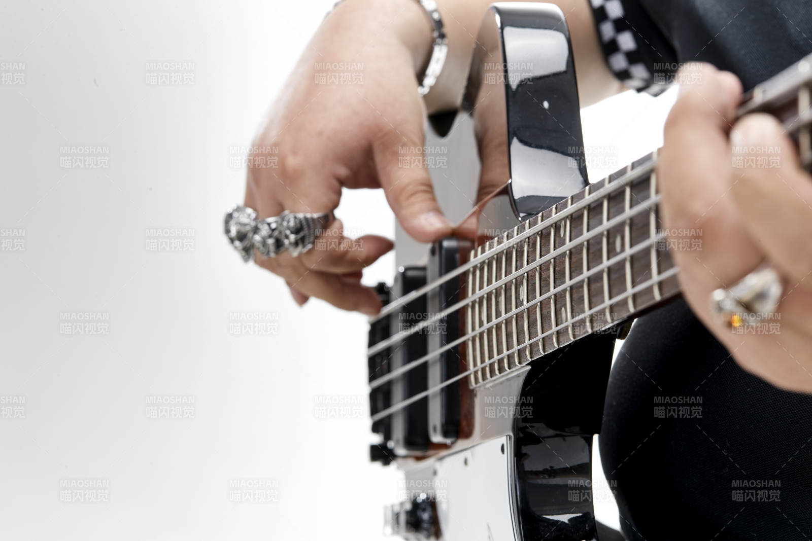 展示贝斯演奏技术技巧的亚洲男性乐手人像局部特写图片