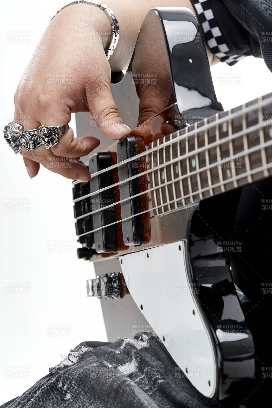 展示贝斯演奏技术技巧的亚洲男性乐手人像局部特写图片