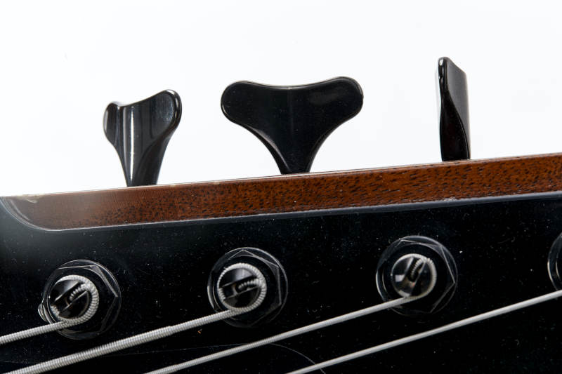 展示贝斯演奏技术技巧的亚洲男性乐手人像局部特写图片